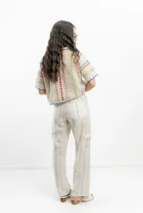 Saco tejido a crochet con diseño a rayas multicolores y detalles en azul.