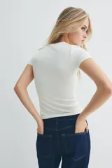 Remera blanca de punto elástico, corte entallado, cuello redondo y bajo recto.