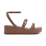 Sandalia color marrón con plataforma texturizada y tiras con apliques de tachas piramidales doradas.
