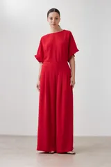 Pantalón palazzo rojo con pinzas, corte amplio y bolsillos laterales.