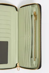 Billetera negra con textura brillante tipo cocodrilo, estructura rígida, logo de la marca en el frente, cierre de cremallera y tarjetero interior.