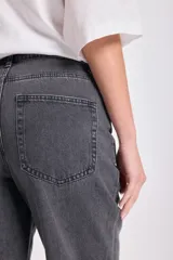 Pantalón jean gris oscuro de corte recto con bajo doblado.