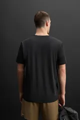 Camiseta deportiva marrón de tejido técnico ligero y elástico con estructura. Cuello redondo, manga corta, costuras planas y logo estampado.