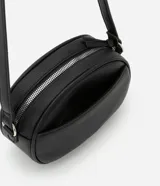 Bolso camera bag pequeño de poliuretano color negro, con forma redondeada, correa ajustable, bolsillo delantero y cierre superior.