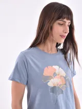 Remera blanca de mangas cortas con estampado de flores y texto en el frente.