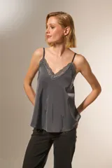 Musculosa negra de bretel fino con escote en V y detalle de encaje en el escote.