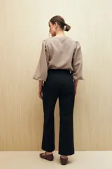 Pantalón recto negro de algodón con tiro medio y bolsillos delanteros.