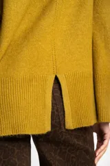 Polera color crema de tejido de punto, con cuello alto y mangas largas.