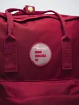 Mochila negra de poliéster con revestimiento de PU, con dos asas de mano y correas ajustables para los hombros. Tiene un compartimento principal con cierre, un bolsillo frontal con cierre y dos bolsillos laterales abiertos.