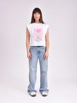 Remera blanca de algodón con cuello redondo y mangas cortas con hombreras. Estampado frontal con un tulipán rosa y texto "Blossom Mood".