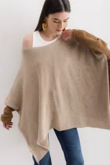 Poncho color beige de algodón tejido, con moldería oversize y tajos en los laterales.