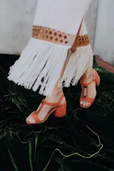Pollera negra con detalle de cuero calado y flecos en la parte inferior.