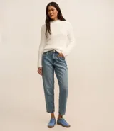 Suéter de punto color blanco, con cuello alto y mangas largas, confeccionado en tejido de peluche.