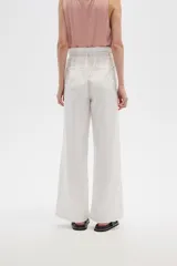 Pantalón de jean color beige, de tiro alto, corte palazzo y estilo paper bag.