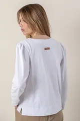 Remera azul marino de mangas largas con detalle de ribete plateado en el centro y en los puños.