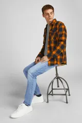 Jean azul de tiro bajo, corte slim fit, con cierre de botón y cinco bolsillos.