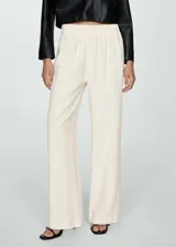 Pantalón wideleg color crudo, de tejido fluido con cintura elástica y tiro alto.