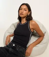 Musculosa negra de algodón con cuello redondo y frisos contrastantes en blanco en el cuello y las sisas.