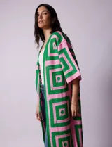 Cardigan largo tejido al crochet con diseño geométrico en verde y rosa. Tiene mangas 3/4 y corte holgado.