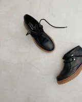 Zapato acordonado negro de cuero vacuno con suela track.