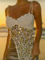 Top de punto color crudo con lentejuelas multicolores, tirantes finos y corte irregular.