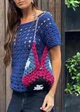 Cartera tejida a crochet, con diseño geométrico multicolor y asa corta.