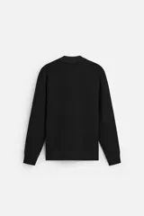 Polo negro de punto con cuello solapa y cierre frontal de cremallera.