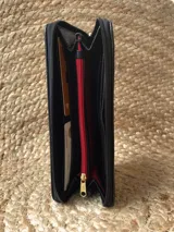 Billetera de cuero con múltiples ranuras para tarjetas y un compartimento con cierre para monedas.