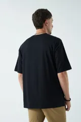 Remera oversize negra de algodón con cuello redondo y mangas cortas. Corte amplio y relajado.