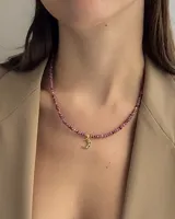 Collar de cinco hilos de cuentas facetadas de jade de Malasia color borgoña, con cuentas doradas y dijes colgantes dorados con incrustaciones de strass: estrella, espiral, mano de Fátima, luna creciente y esqueleto de pez.