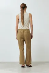 Musculosa de punto canalé color beige con cuello en V y ribete blanco en contraste.