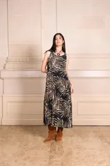 Vestido midi plisado con estampado de hojas en tonos marrones y ribete blanco en cuello y sisas.