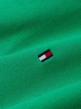 Chomba verde de corte slim, con cuello polo, tapeta de dos botones y logo de Tommy Hilfiger bordado en el pecho.