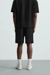 Bermuda negra de corte relaxed fit, con cintura elástica ajustable con cordón, bolsillos frontales y bolsillo trasero de parche.