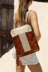 Mochila de cuero en tonos marrón y beige, con diseño moderno y asas ajustables.