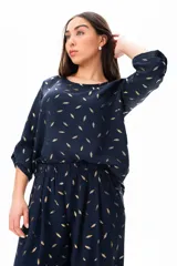 Blusa azul con estampado de hojas doradas, de mangas 3/4 y corte holgado.