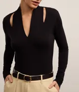 Blusa negra de mangas largas confeccionada en viscosa, con cuello alto, escote V y aberturas en los hombros.