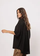 Camisa negra con calados, escote en V, abotonada y manga 3/4.