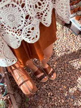 Sandalias bajas de cuero marrón con estampado animal print en las tiras.