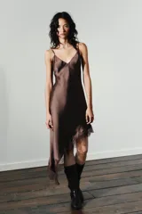 Vestido midi marrón satinado con escote en V, tirantes finos regulables, espalda descubierta con lazo y bajo asimétrico con encaje a tono.