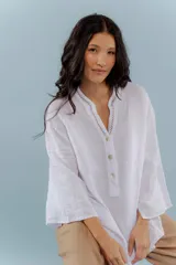Camisa blanca de lino con escote en V y bordado multicolor en el cuello.