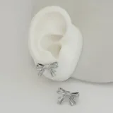 Par de aros plateados con forma de moño.