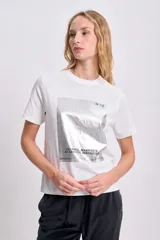 Remera blanca de corte recto y mangas cortas, con estampa rectangular en el frente con imagen abstracta en tonos plateados y texto "Cultural Manifesto of Artistic Innovation".