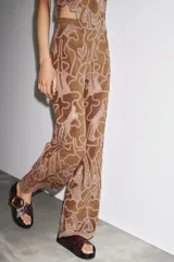 Pantalón marrón de tiro alto confeccionado en tejido efecto ante con aplicación de crochet a contraste.