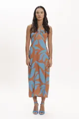 Vestido midi con estampado de hojas en tonos celeste y naranja, con escote halter y abertura en la cintura.