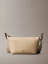 Cartera de hombro Calvin Klein color beige, confeccionada en cuero sintético granulado. Presenta correa ajustable con jacquard con logo, cierre de cremallera en la parte superior, bolsillo interior con ranura para tarjetas y monograma distintivo grabado en la parte delantera.