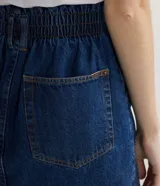 Falda corta de jean azul con cintura alta elastizada y doble botón.