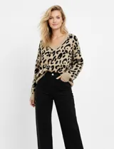 Buzo tejido de lana color beige con estampado animal print de leopardo en negro, escote en V y mangas largas. Marca Q2, talle Medium.