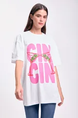 Remera blanca de corte amplio con estampado de copas de martini rosadas con aceitunas verdes.