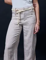 Pantalón capri de lino color beige con estampado floral, marca Zac & Rachel. Tiene pretina con pasadores, cierre y botón. Incluye cinturón de cordones con hebilla metálica. Presenta bolsillos delanteros con botones y bolsillos traseros.